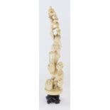 A late 19thC Japanese ivory okimono figure group, depicting a man at the foot of a fruit tree, with