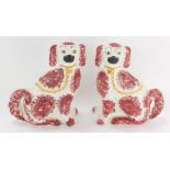 A pair of Staffordshire spaniels, each with red mottled ground, unmarked, 32cm high.