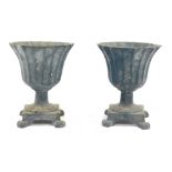 A pair of cast campana vases, each with a flared rim, on a square set base with ball claw feet, 17cm