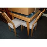 A beech extending dining table and four chairs.