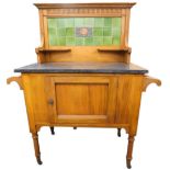 A late Victorian walnut washstand, the raised back inset with plain green tiles surrounding a centra