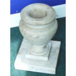 A baluster shaped marble floor urn, on a square plinth, 36cm high.