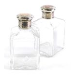 A pair of early 20thC perfume bottles, each with square bodies and removable white metal lids, with