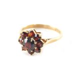 A 9ct gold garnet cluster ring, with central faceted stone surrounded by eight smaller stones, each