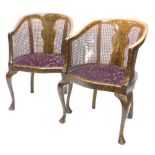 A pair of early 20thC tub shaped bergere chairs, each painted to simulate walnut, with a padded seat