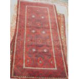 A full pile hand woven Persian Nomadic rug, with design of medallions in red, on a navy ground, with