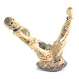 An early 20thC carved antler figure comprised of two skeletons, 10cm high.