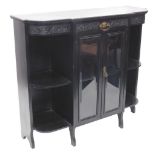 A late 19th/early 20thC ebonised side cabinet, with a shaped top above a carved frieze and two glaze
