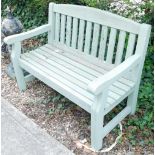 A green painted and slated garden bench, 123cm wide.