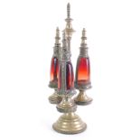 A Middle Eastern metal and ruby glass bottle decanter, with cylindrical stem with garland handle, on