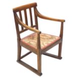A 19thC country made elm open armchair, with a slatted back, and padded seat on end supports.