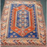 A Persian Kazak type rug, with a central medallion decorated with animals and geometric devices, on