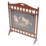 An early 19thC mahogany firescreen, the rectangular panel inserted with a crewelwork of poppies, on