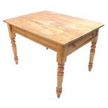 A Victorian pine kitchen table, the plank top above a drawer to one end, on turned tapering legs, 74