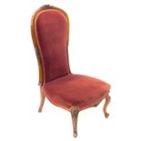 A Victorian walnut spoon back nursing chair, with a padded back and seat, on cabriole legs.