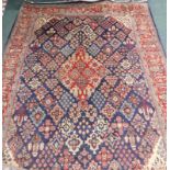A Persian carpet, with a design of floral lozenges, on a blue ground, with one wide and two narrow b