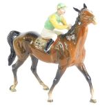 A Beswick racehorse and jockey, number 1037, with twenty four saddle cloth, green and yellow silks,