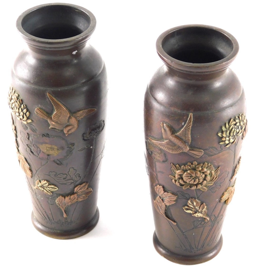 A pair of Japanese Meiji period bronze vases, each circular body raised with birds and flowers, on c