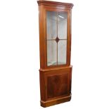 A Charles Barr walnut standing corner cabinet, with a glazed door enclosing adjustable shelves above