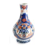 An early 20thC Imari bottle vase, of bulbous form, painted with panels of birds, trees, and building