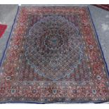 A Persian rug, with a central cartouche shaped medallion, in pale blue, on a navy blue ground, with