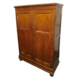 An early 20thC oak and pine wardrobe or cupboard, with two panelled doors on bun feet, 157cm high, 1