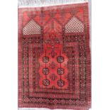 A Turkoman type prayer rug, with a design of medallions, on a deep red ground with multiple borders,