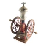 A late 19thC MFG Co. Enterprise manual iron coffee grinder, with two articulated side wheels, and fr