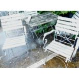 A slatted and silver painted wrought iron garden table and four folding chairs.