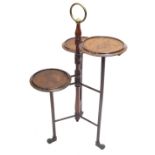 An unusual early 20thC mahogany three tier cake stand, with brass handle on turned supports, with ca