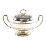 An early 20thC silver plated two handled sauce tureen, partially gadrooned, with crest, strap swan n