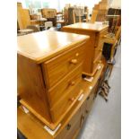 A pair of pine effect three drawer bedside chests.