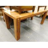 A large rectangular hardwood dining table on heavy square section legs.