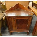 A mahogany free standing corner cabinet with raised back above a panelled door on cabriole legs. (AF