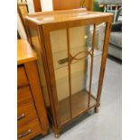 A walnut display cabinet with a single glazed door.