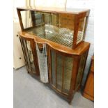 A 1950's/60's walnut display cabinet, the top with two sliding doors above two bow doors flanking a