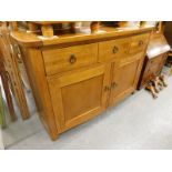 An oak bow front sideboard with drawers above two panelled doors, on stiles.