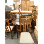 A beech circular dining table and various oak dining chairs.