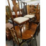 A walnut extending dining table and four various Queen Anne style chairs.