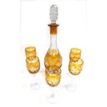 A Bohemian amber flash glass decanter and stopper, floral engraved, together with five stemmed wine