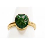 A dress ring, with polished green stone in a rub over setting, on a plain band, yellow metal, stampe