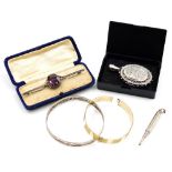 A filigree hinged bangle, white metal unmarked, an amethyst coloured paste stone set bar brooch, wit