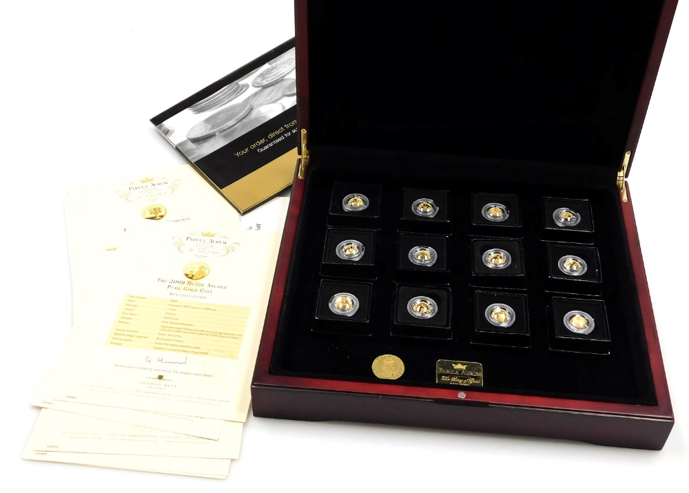 A set of twelve Fabula Aurum gold coins, from the year 2009, with certificates, boxed, each 0.5g.