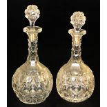A pair of Victorian globe and shaft glass decanters, with slice cut slender necks and faceted bodies