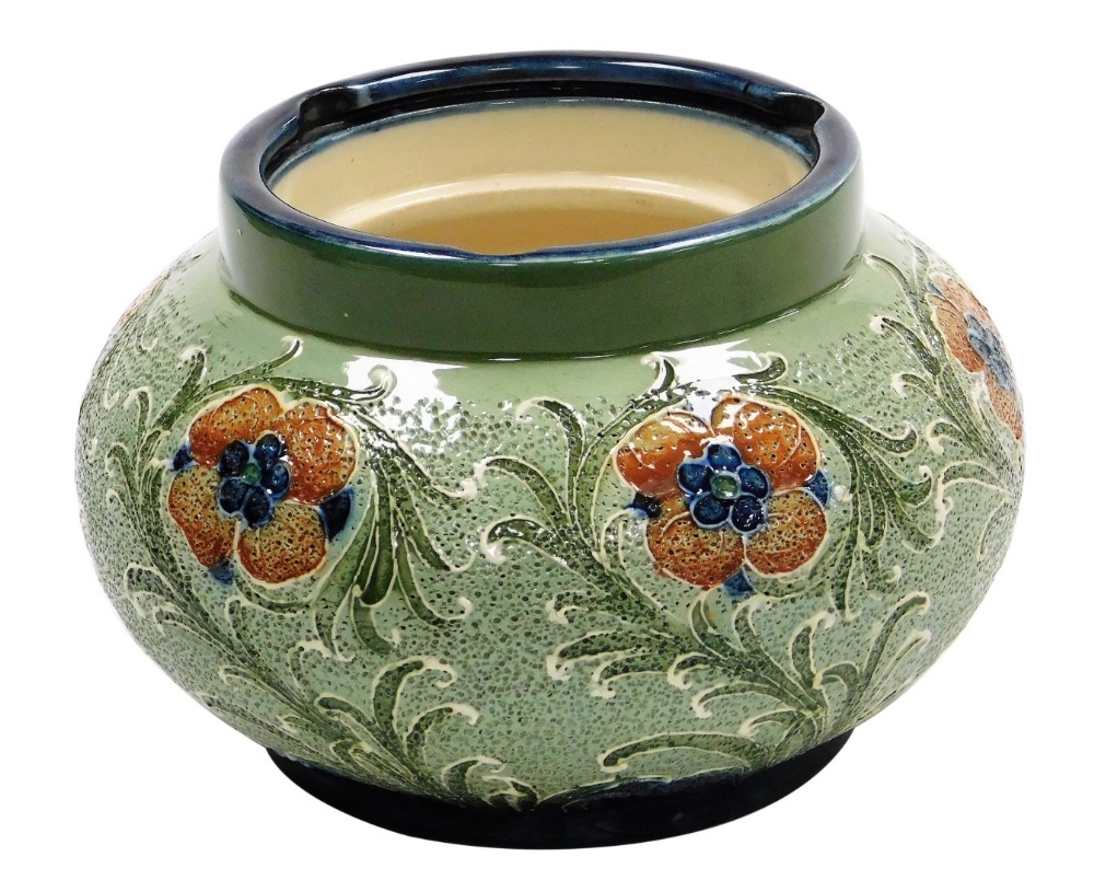 A Moorcroft Macintyre and Co Florian ware pottery tobacco jar, decorated with flowers against a text