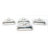 A set of four George V silver entree dishes, each with applied swivel branch handle, and part fluted