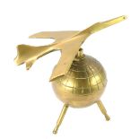 A retro brass desk weight, modelled as a jet plane atop a Sputnik globe, 12.5cm wide.