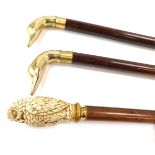 Three walking canes, comprising a resin handled owl cane and two brass duck headed walking canes. (