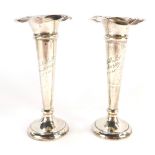 A pair of Edward VII loaded silver bud vases, each with a flared rim, one bearing the inscription To
