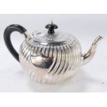 A Victorian silver teapot, of spiral fluted form with shield reserve, armorial engraved, rubbed